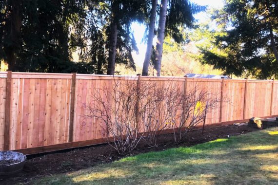 Cedar cap and trim fence with retaining wall in Eugene.